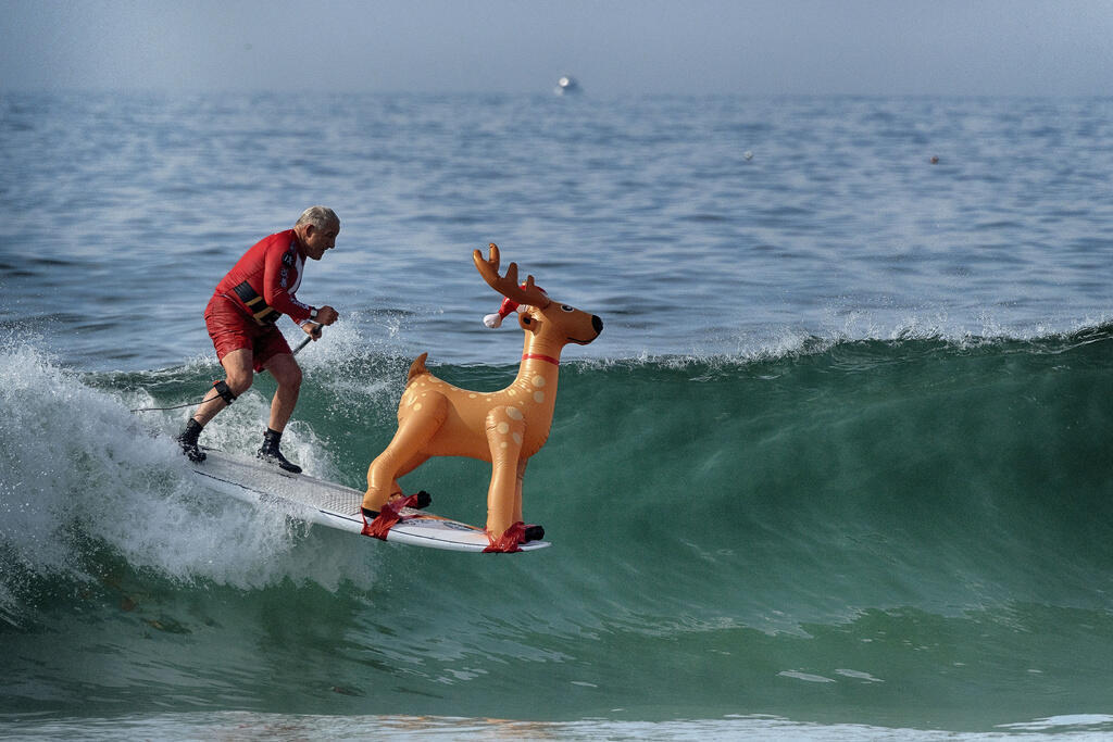 Image non contractuelle de Rodolphe le renne lorsqu'il n'est pas connecté aux réacteurs nucléaires, ici sur sa planche à pagaie lors de l'événement Surfing Santa à Dana Point, en Californie, le dimanche 8 décembre 2024.