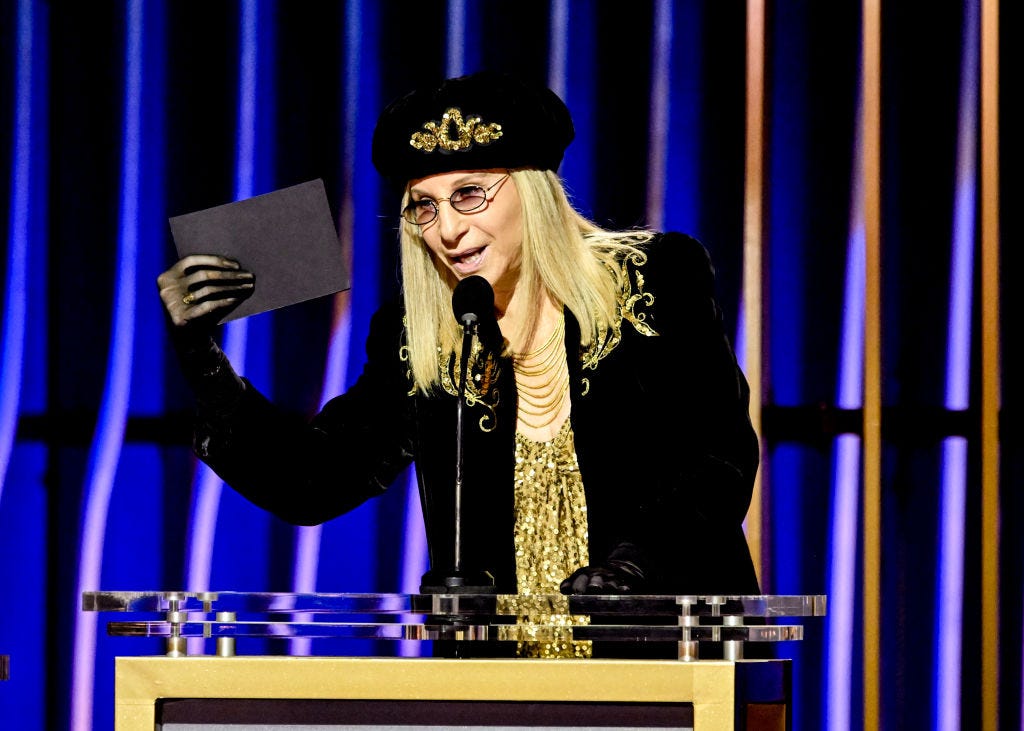 Barbra Streisand speaking at a podium.