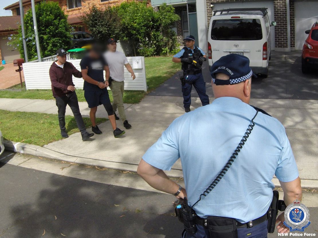 A suspect, who's face has been blurred in this handout photo from NSW police, is taken into custody. Raptor Squad detectives have dismantled a criminal syndicate allegedly attempting to export over $1m worth of Australian native lizards and reptiles to Hong Kong.