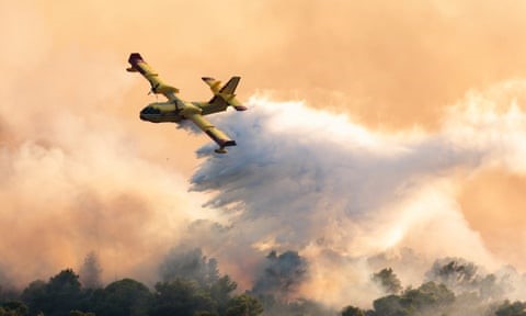 A firefighting plane sprays water to extinguish wildfires at Ciovo island, Croatia